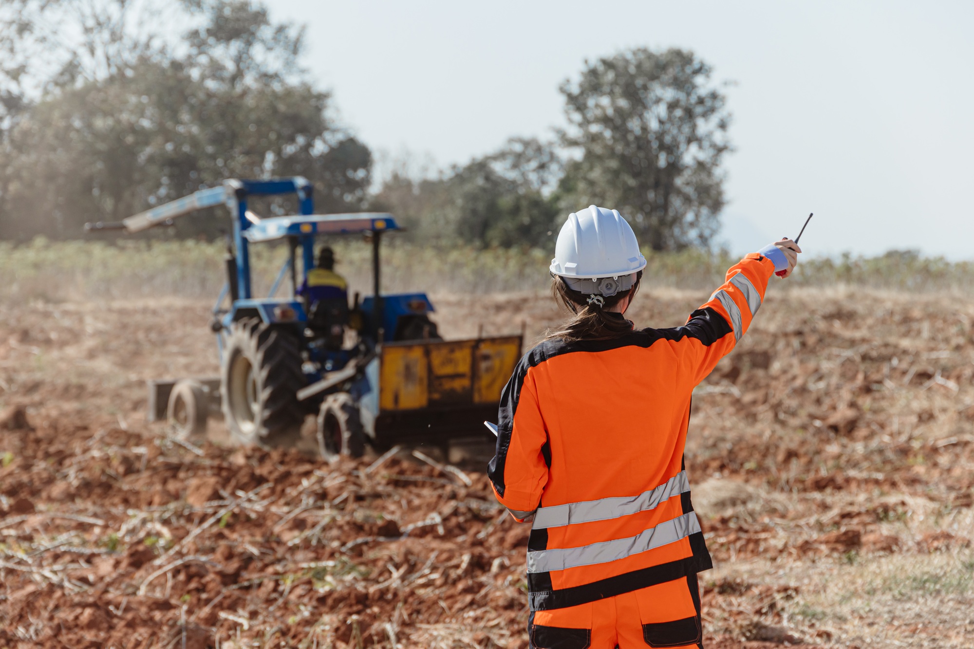 Builder worker work in construction site wearing safety suit control operate land leveling process